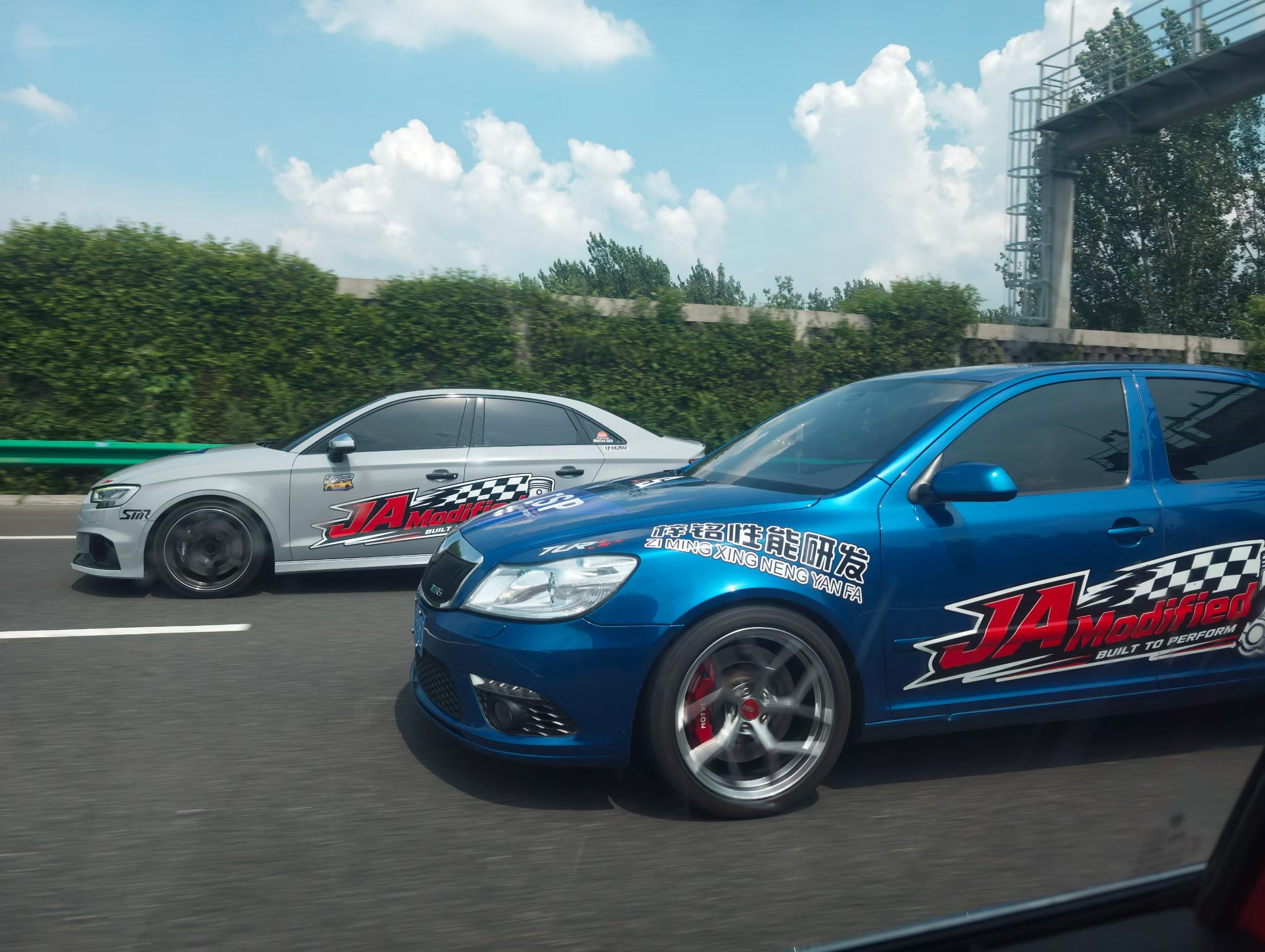 Two JA-Modified performance cars driving together